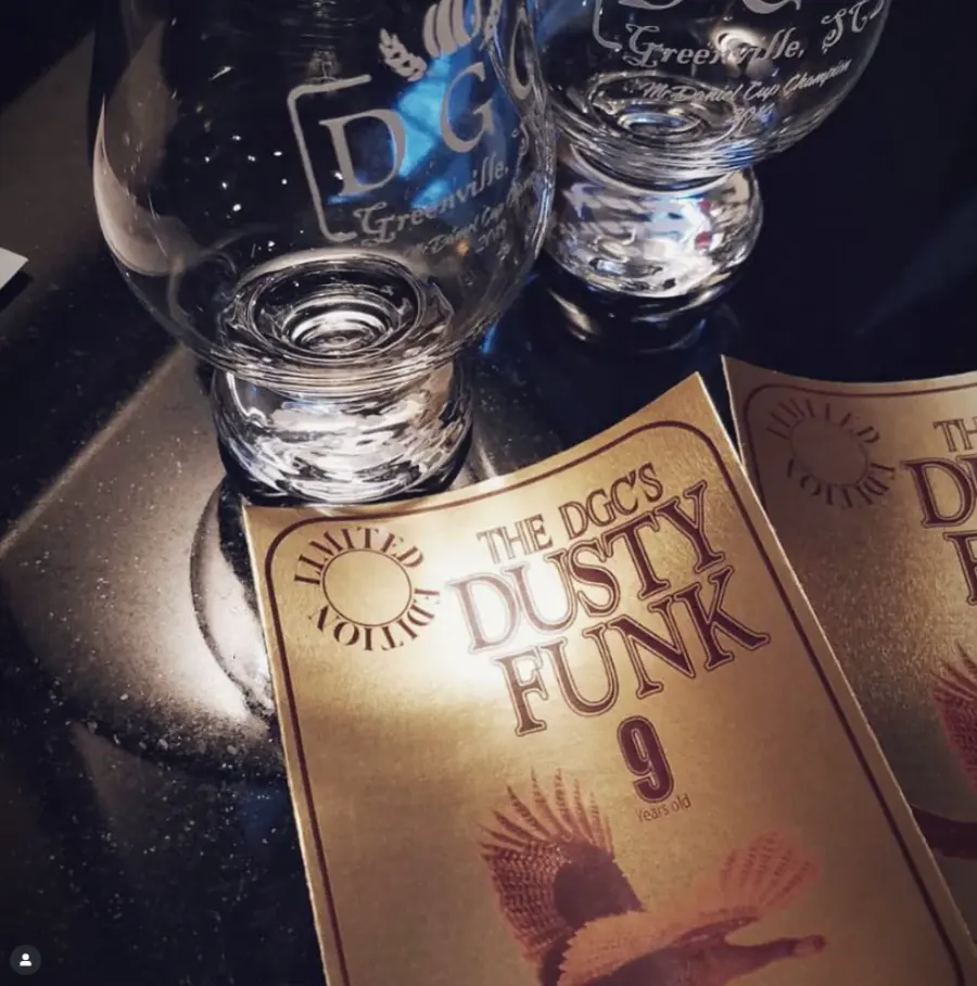 Engraved DGC Glencairn glasses beside gold Dusty Funk limited edition barrel-pick labels